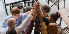 A group of students high-five each other.